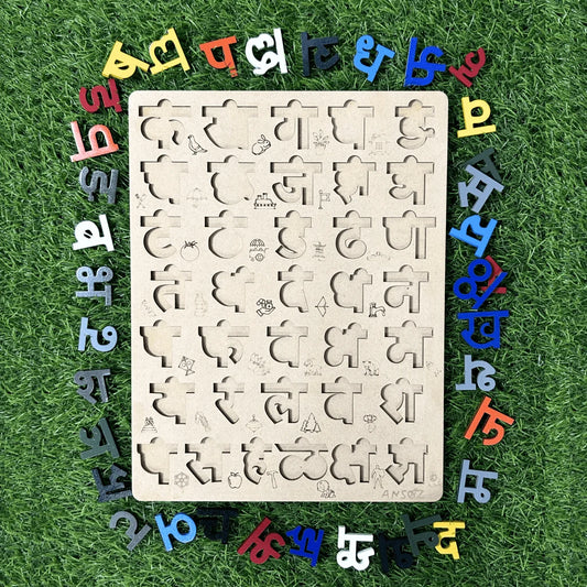 A wooden educational puzzle board with cutout shapes and marathi characters, surrounded by colorful loose letters on a green grass-like background.