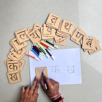 Kids playing with Hindi alphabet stencils to learn writing Hindi consonants
