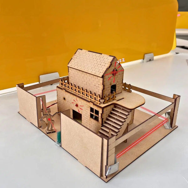 Wooden Laser Security System DIY Kit featuring a laser-cut house model with security alarm mechanism for kids' science learning