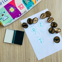 number stamps placed around paper with printed numbers and ink pad 