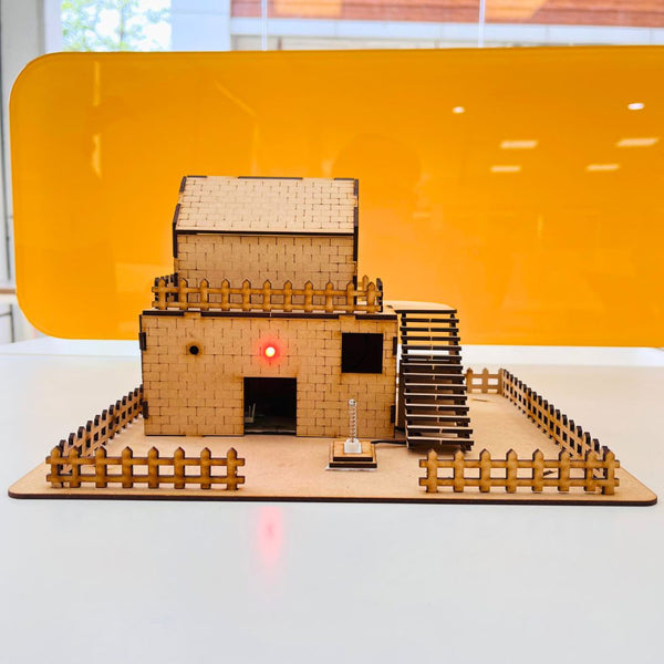 DIY Earthquake Alarm System working model showing wooden house structure with LED alert on vibration detection