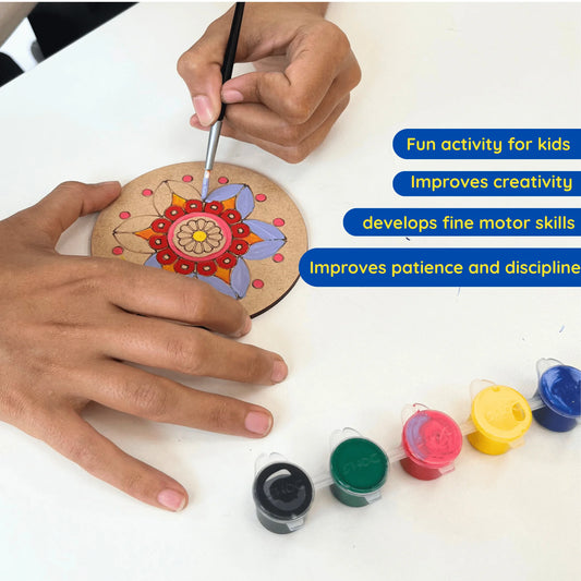 A person's hands are shown painting a circular wooden plaque with a colorful mandala design, with four small paint pots lined up on a white table. Blue text overlays on the right list benefits like 'Fun activity for kids' and 'Improves creativity'.