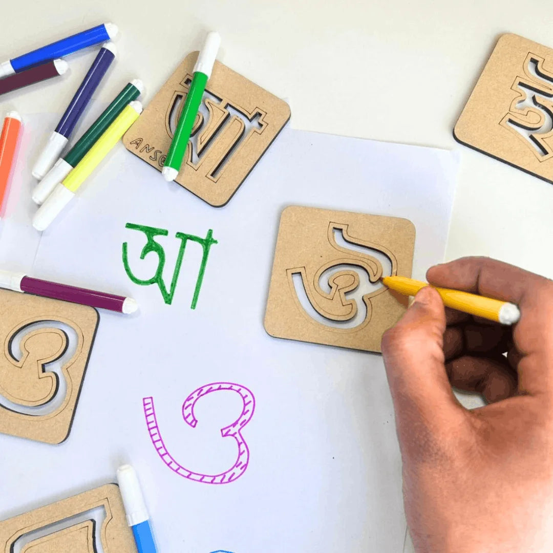  Child tracing Assamese alphabet letters using reusable wooden stencil kit with colorful sketch pens, promoting handwriting, creativity, and early Assamese language learning.