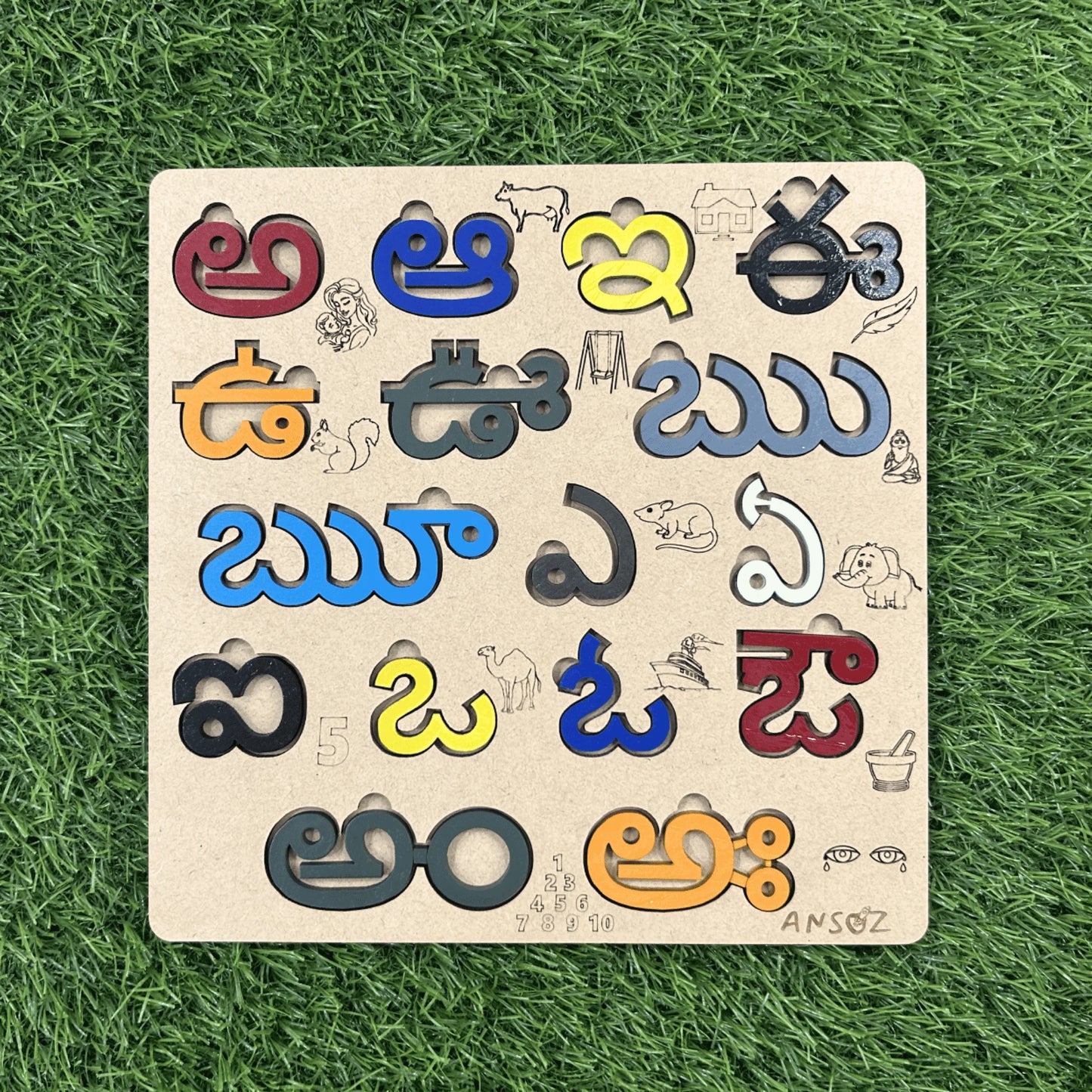 A wooden educational puzzle board featuring colorful Devanagari script letters and small animal illustrations, placed on a green grass background.