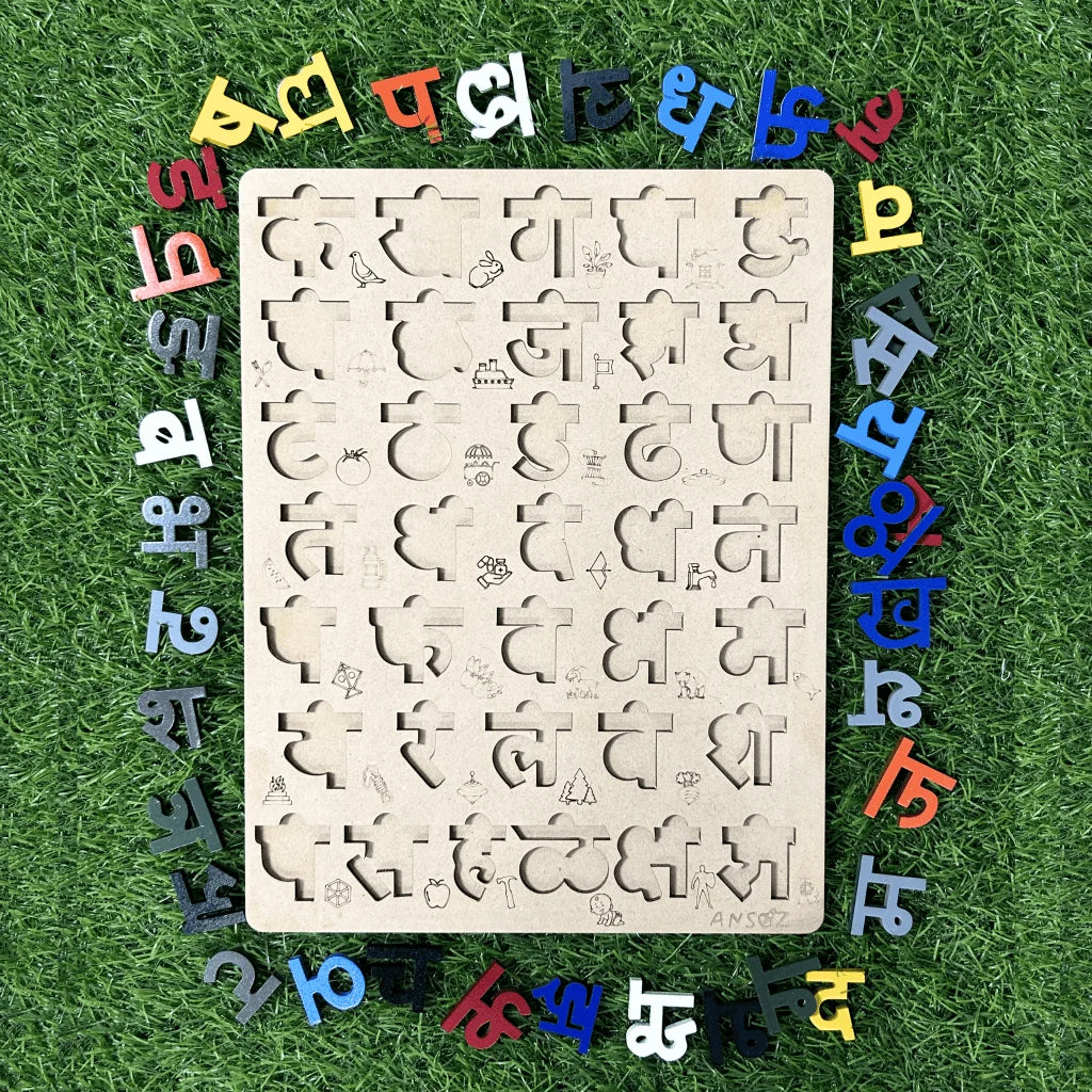 A wooden educational puzzle board with cutout shapes and marathi characters, surrounded by colorful loose letters on a green grass-like background.