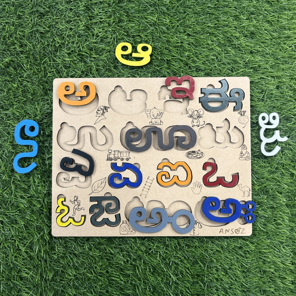 A wooden educational puzzle board featuring carved slots and colorful movable letters in Telugu script, displayed on a green grass-like surface. The letters are scattered around the board, including yellow, blue, orange, red, and gray pieces.