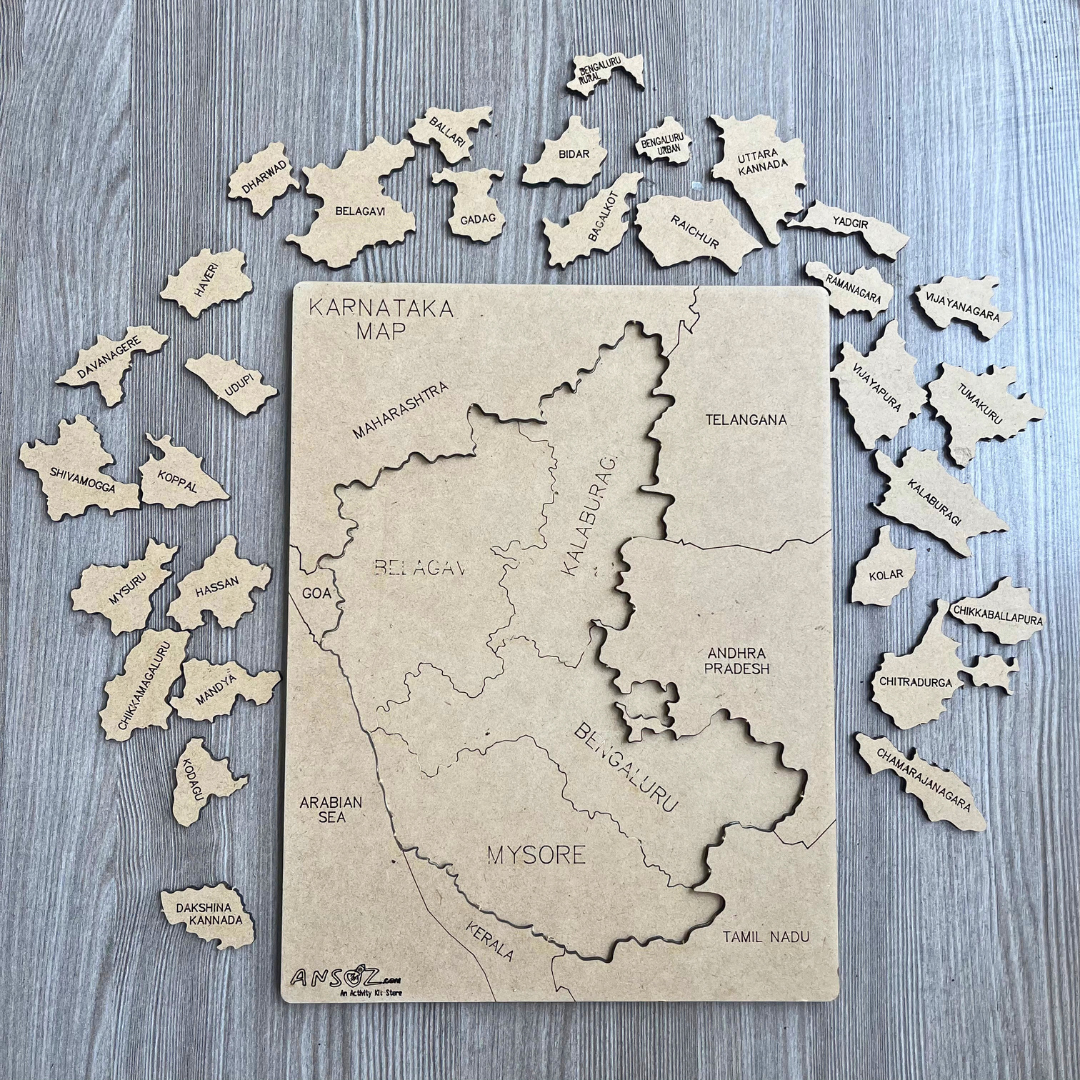 Karnataka state map puzzle with district pieces removed, laid out around the wooden board