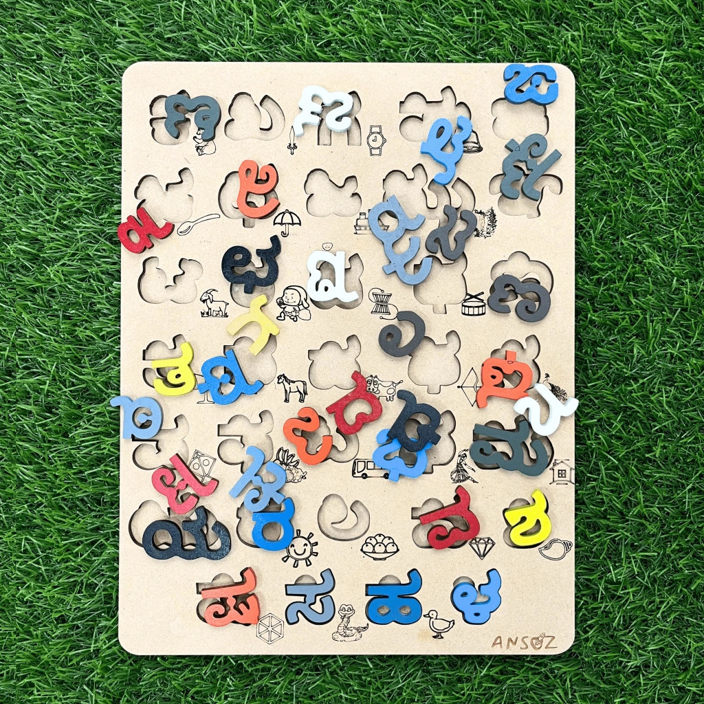 A wooden alphabet puzzle board with colorful letter pieces scattered on a green grass-like background. The board has cutout letters and small illustrated shapes, and the brand name 'ANSOZ' is visible in the bottom right corner.