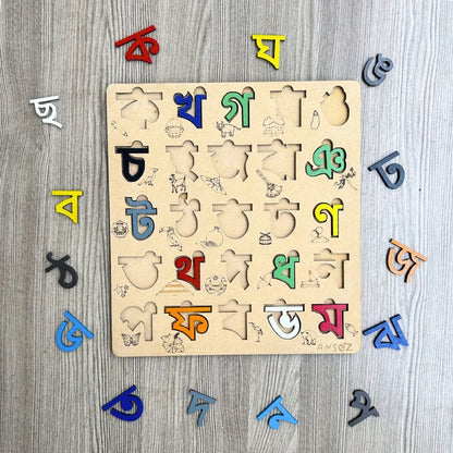 A wooden Bengali alphabet puzzle board with colorful movable letters arranged around it on a gray wood-textured background.