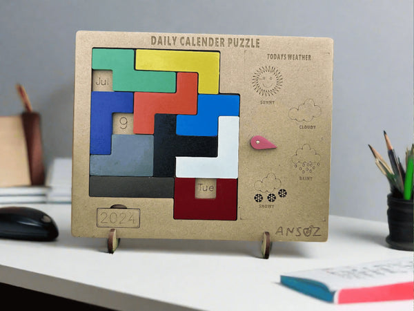 A wooden daily calendar puzzle stand on a white desk, featuring colorful sliding puzzle blocks and weather icons. The product is branded with the name 'ANSOZ' on the bottom right.
